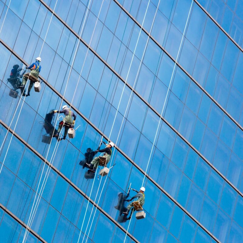 men cleaning windows of a building for a clear view.